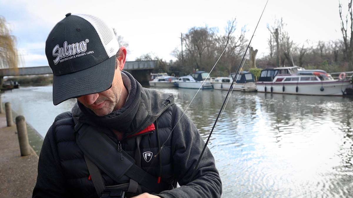 Playing a perch on crankbait tackle by the riverside