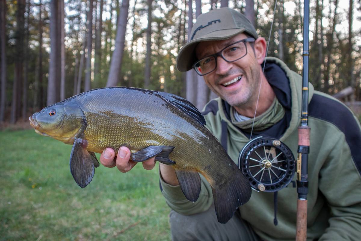 A feeder rod bent over as a fish is being played.